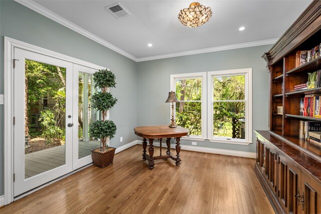 doorway with baseboards, healthy amount of natural light, light wood-style flooring, crown molding, and recessed lighting