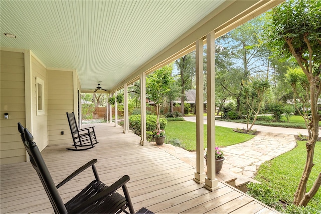 wooden deck featuring a yard, ceiling fan, and a porch