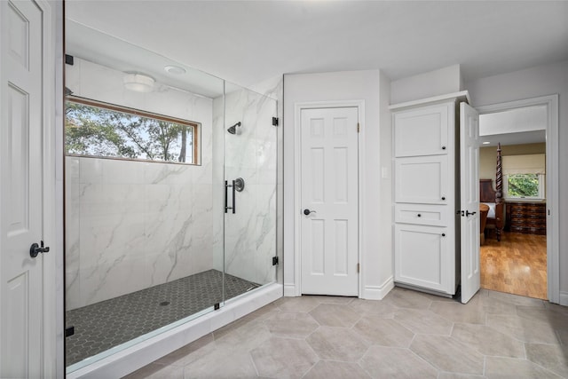 ensuite bathroom with healthy amount of natural light and a marble finish shower