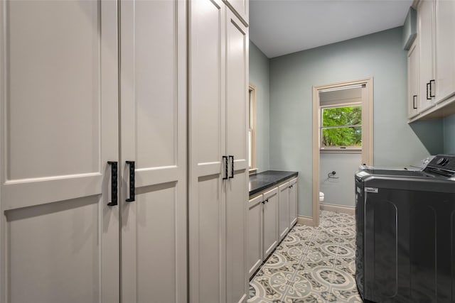laundry area with cabinet space, washing machine and dryer, and baseboards
