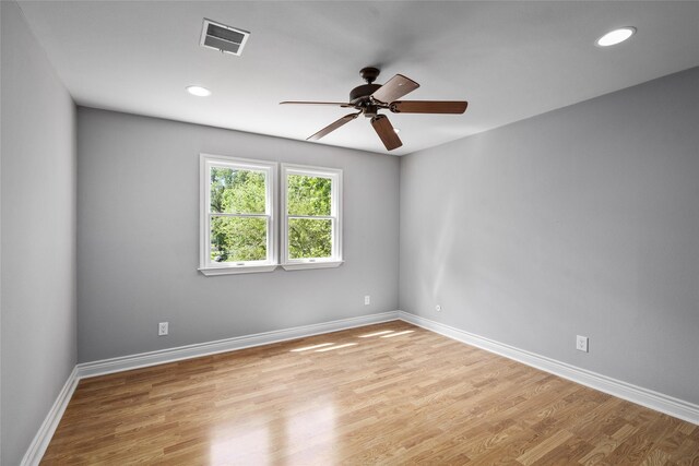 empty room with light wood finished floors, a ceiling fan, baseboards, and recessed lighting