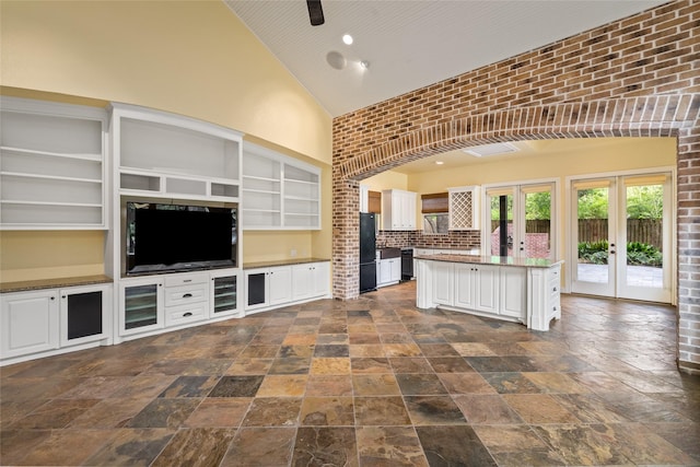 kitchen featuring high vaulted ceiling, french doors, freestanding refrigerator, dishwasher, and white cabinetry