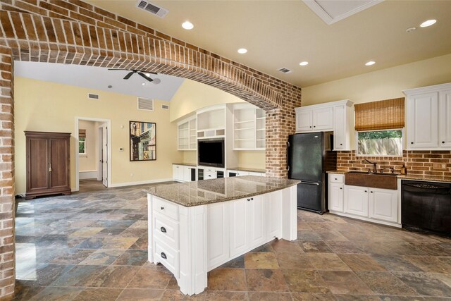 kitchen featuring black appliances, stone tile flooring, a center island, a sink, and recessed lighting