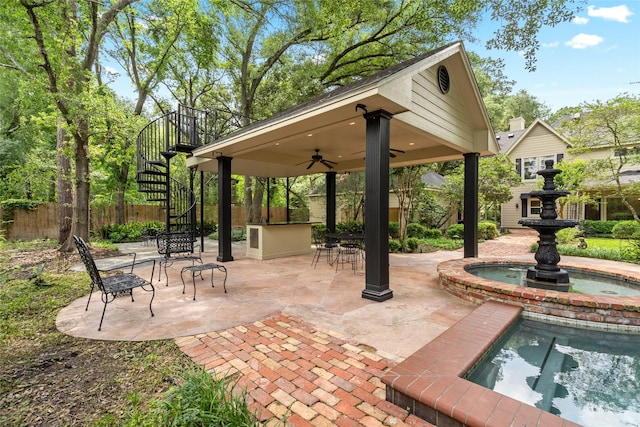 view of patio with stairway, fence, a ceiling fan, and exterior bar