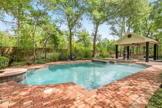 view of pool with a fenced backyard, a pool with connected hot tub, a ceiling fan, and a patio area