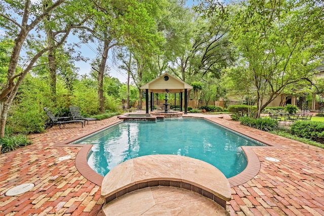 view of swimming pool featuring a pool with connected hot tub, fence, and a patio area
