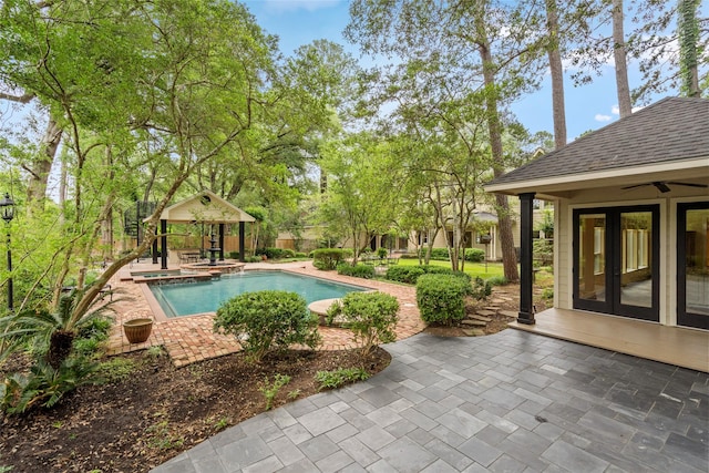 view of pool featuring a patio, french doors, a pool with connected hot tub, a gazebo, and a ceiling fan