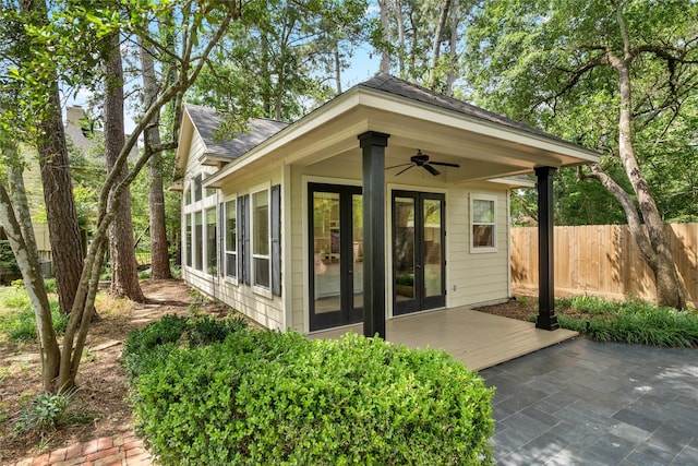 view of outbuilding featuring french doors and fence