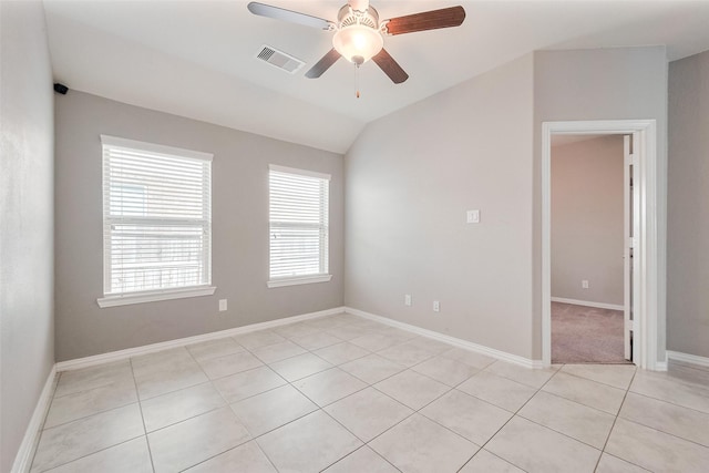unfurnished room featuring visible vents, vaulted ceiling, a ceiling fan, light tile patterned floors, and baseboards