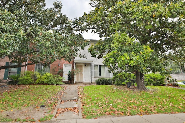 view of front of house with a front yard and brick siding