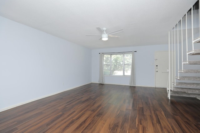 unfurnished living room featuring stairs, ceiling fan, and dark wood-style flooring