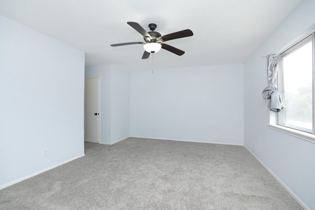 empty room featuring ceiling fan, carpet floors, and baseboards