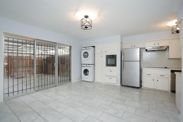 kitchen with stacked washer / dryer, freestanding refrigerator, under cabinet range hood, white cabinets, and wall oven