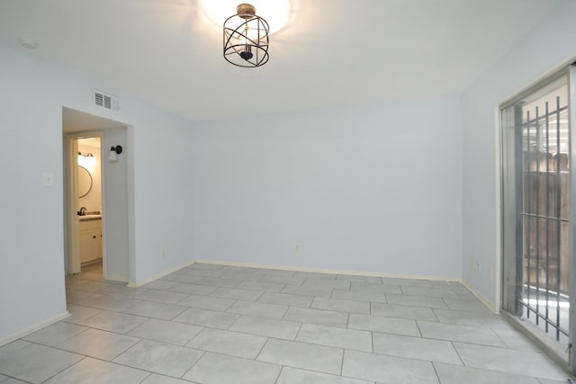 unfurnished room with light tile patterned floors, visible vents, and baseboards
