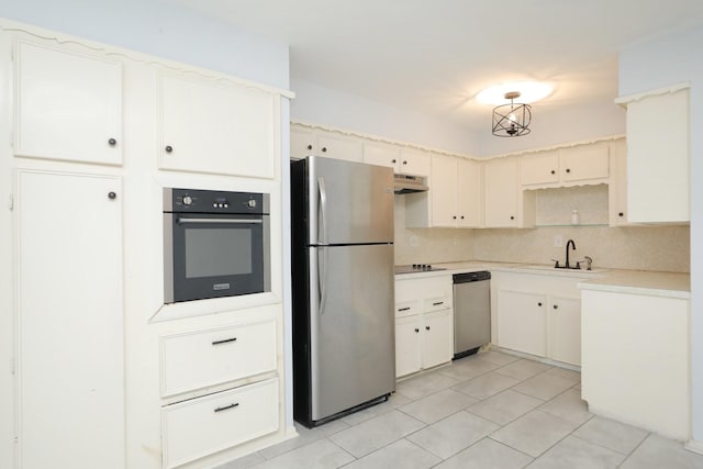 kitchen featuring under cabinet range hood, a sink, backsplash, light countertops, and appliances with stainless steel finishes