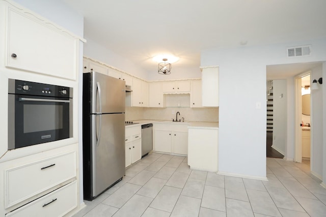 kitchen featuring a sink, black appliances, visible vents, light countertops, and light tile patterned floors