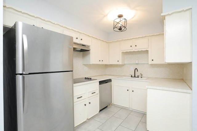kitchen with under cabinet range hood, a sink, backsplash, light countertops, and appliances with stainless steel finishes