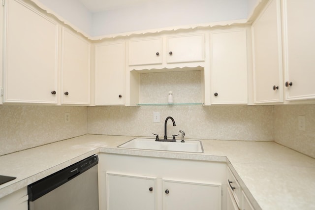 kitchen with stainless steel dishwasher, a sink, backsplash, light countertops, and white cabinets