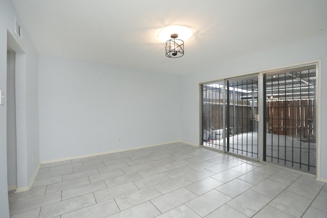 empty room with baseboards, tile patterned flooring, and visible vents
