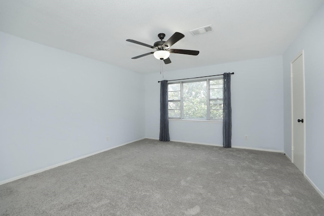 carpeted empty room featuring baseboards, ceiling fan, and visible vents