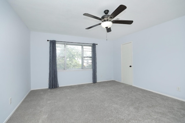 carpeted empty room with baseboards and a ceiling fan