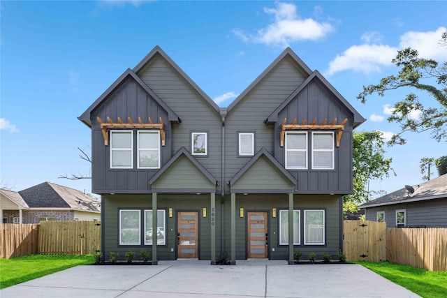 view of front of house with board and batten siding, fence, and a gate