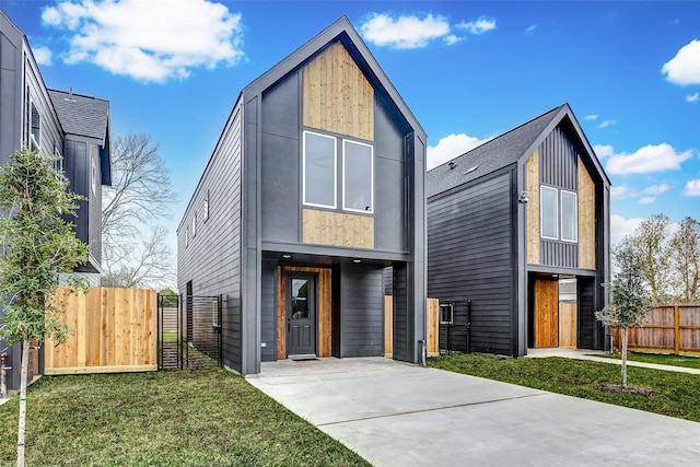 modern home featuring a gate, fence, and a front yard