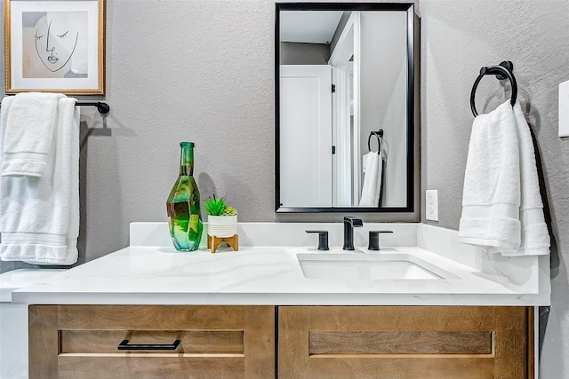 bathroom featuring vanity and a textured wall