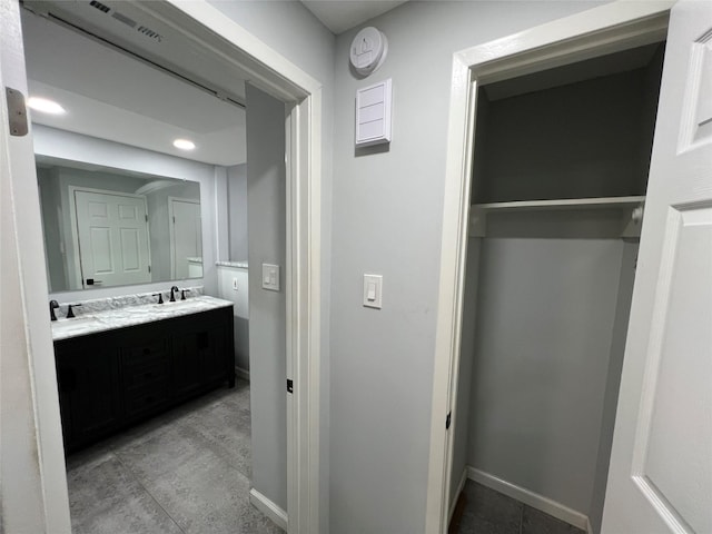 bathroom with double vanity, baseboards, tile patterned flooring, and recessed lighting