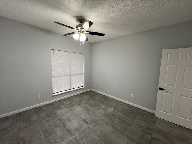 empty room with a ceiling fan, a textured ceiling, and baseboards