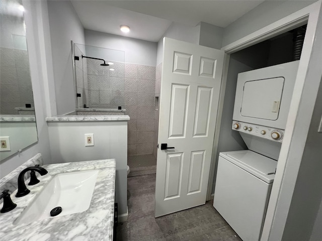 bathroom with stacked washing machine and dryer, walk in shower, vanity, and tile patterned floors