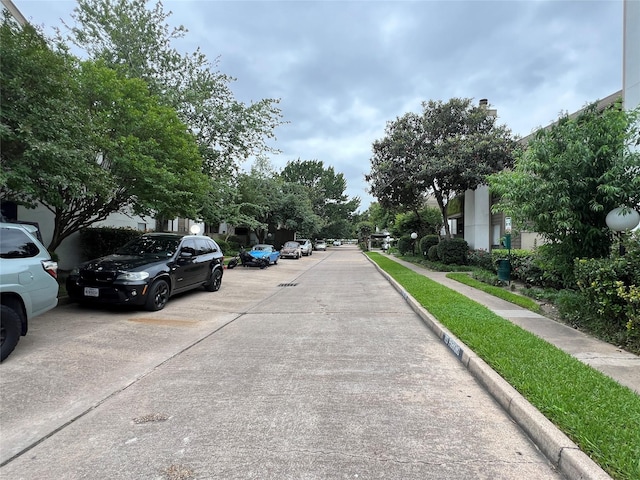 view of concrete street featuring sidewalks, curbs, and a residential view