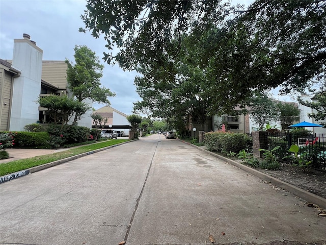 view of concrete street featuring curbs