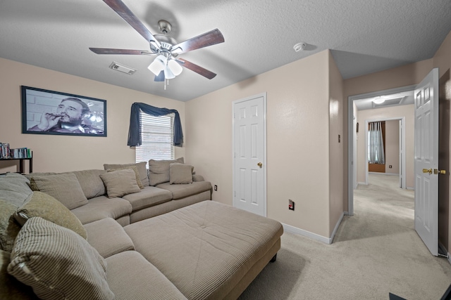 living room with light colored carpet, visible vents, baseboards, and a ceiling fan
