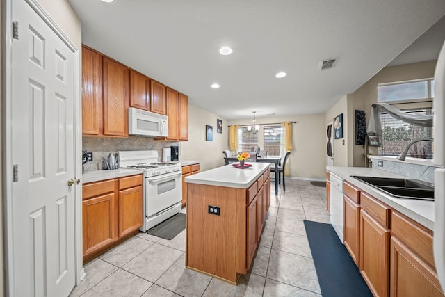 kitchen featuring a sink, white appliances, recessed lighting, decorative backsplash, and a center island