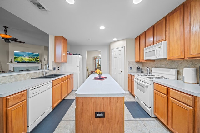 kitchen with white appliances, decorative backsplash, a sink, and a kitchen island