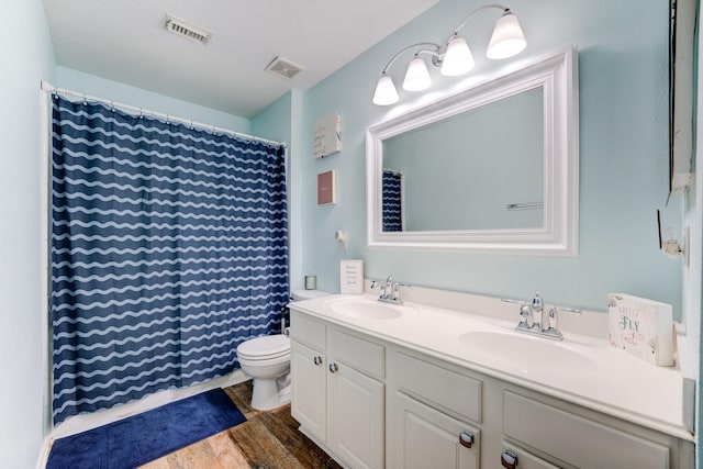 full bathroom with a sink, visible vents, and wood finished floors