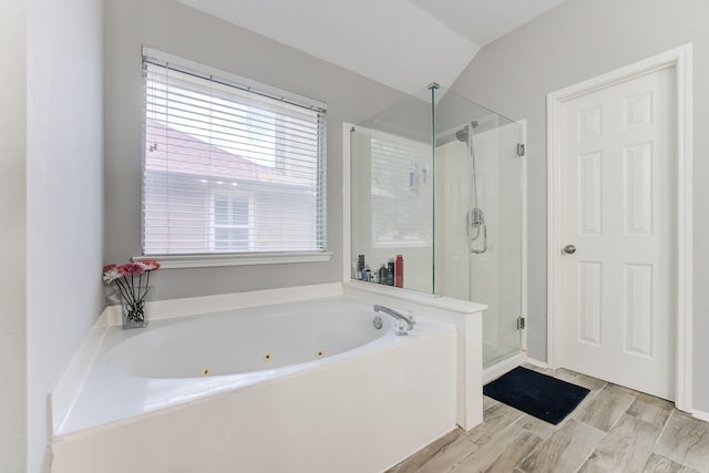 full bath featuring a whirlpool tub, a stall shower, and lofted ceiling