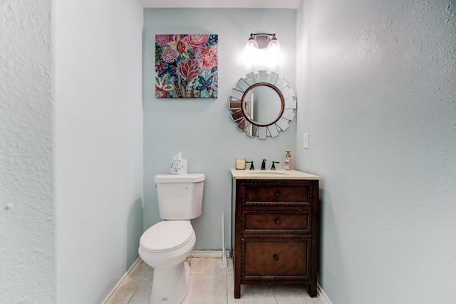 bathroom with vanity, toilet, baseboards, and tile patterned floors