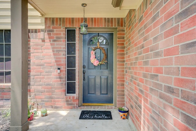 view of exterior entry featuring brick siding