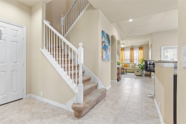 foyer entrance with recessed lighting, light tile patterned floors, baseboards, and stairs