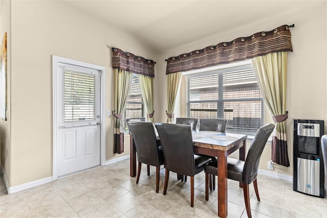 dining area featuring light tile patterned flooring, baseboards, and lofted ceiling