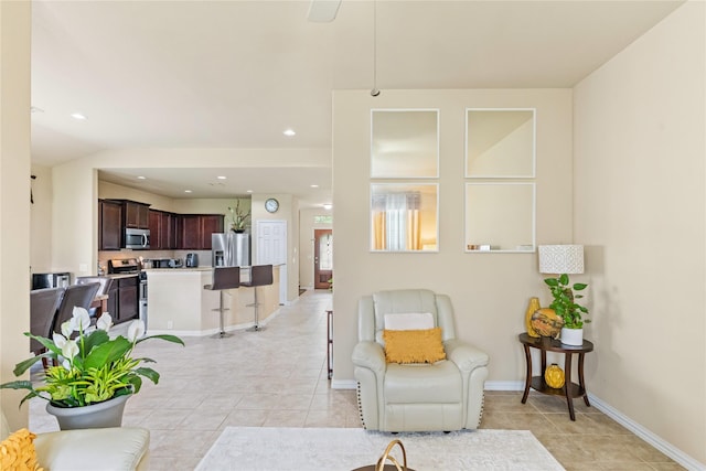living area with light tile patterned floors, baseboards, and recessed lighting
