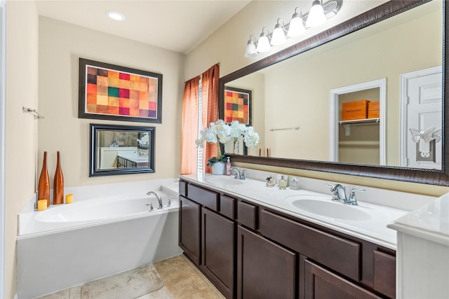 full bathroom featuring tile patterned flooring, a garden tub, double vanity, and a sink
