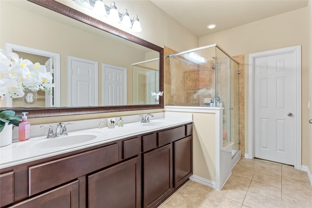 full bath featuring double vanity, tile patterned floors, a shower stall, and a sink