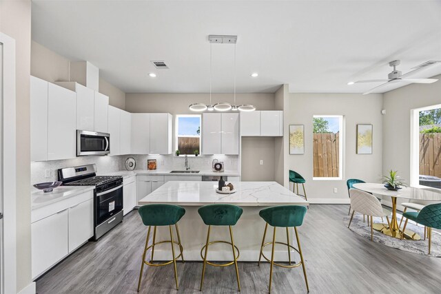855 Prosper St, Houston, TX 77088 - kitchen featuring light wood-style floors, stainless steel appliances, a kitchen breakfast bar, and visible vents