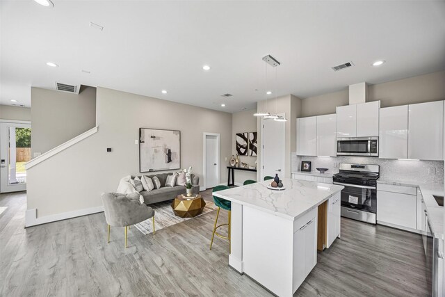 855 Prosper St, Houston, TX 77088 - kitchen with a kitchen island, appliances with stainless steel finishes, visible vents, and light wood-type flooring
