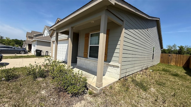 117 Avalon Dr, Huntsville, TX 77320 - view of side of home featuring fence, an attached garage, and driveway