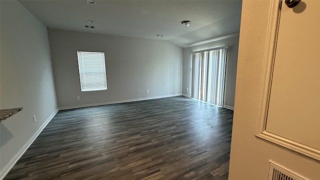 117 Avalon Dr, Huntsville, TX 77320 - empty room featuring lofted ceiling, baseboards, dark wood-type flooring, and visible vents