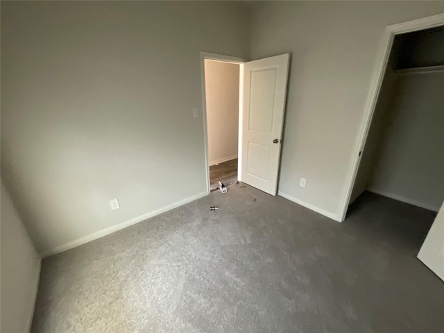 117 Avalon Dr, Huntsville, TX 77320 - unfurnished bedroom with a spacious closet, baseboards, a closet, and dark carpet